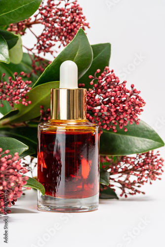 Elegant Dropper Bottle with Red Serum and Floral Decor photo