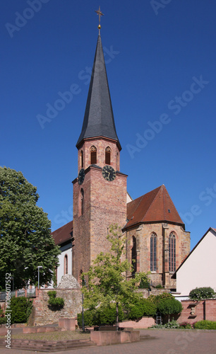 Medieval church with bell tower and gothic apse in the old village of Herxheim bei Landau, Rheinland-Pfalz region in Germany photo