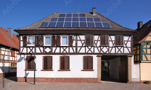 A half-timbered baroque residential house with solar collectors on its roof in the old village of Herxheim bei Landau, Pfalz region in Germany photo