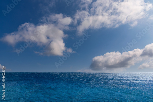 Seascape with blue sea over blue sky with white clouds with sun reflections. Seen panorama over Mediterranean sea seen from Corsica Island, France