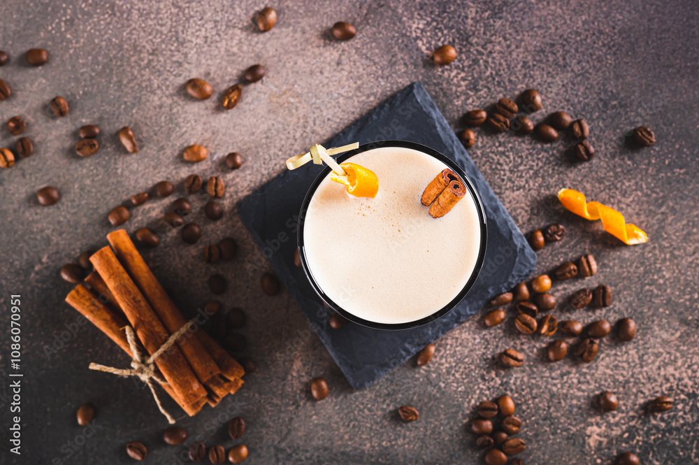 Close up of spanish coffee cocktail with cinnamon and orange zest in a glass on table top view