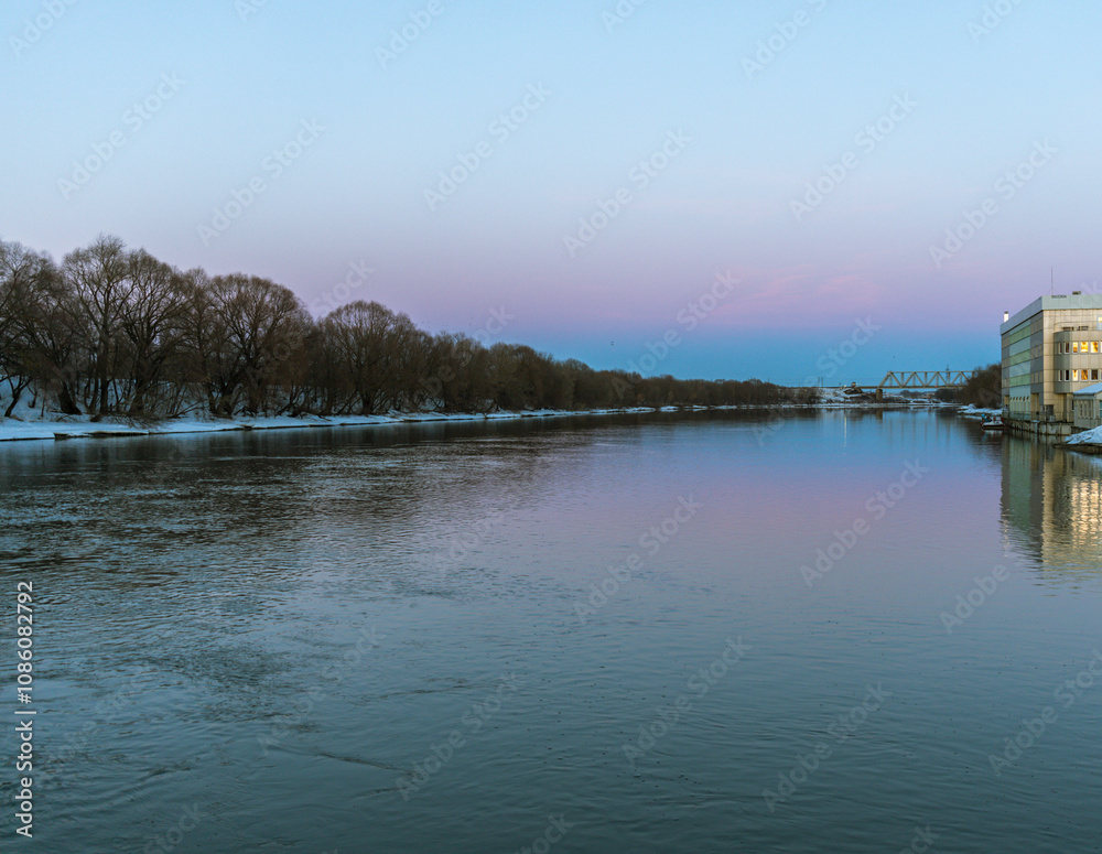 A calm river with a beautiful blue sky in the background A calm river with a beautiful blue sky in the background