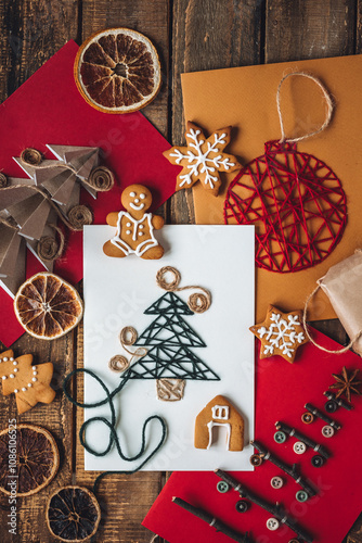 Cute handmade postcard with fir tree embroidering with green threads on wooden background. Homemade gingerbread cookies. Holiday craft, family tradition, quality time, simple easy do it yourself decor photo