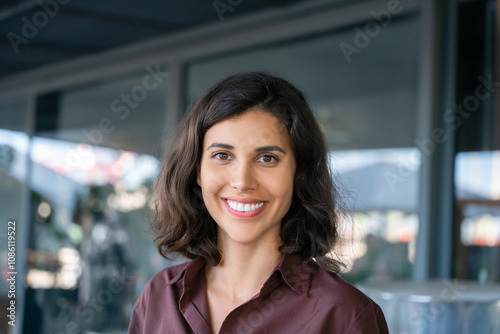 Closeup headshot face portrait of beautiful successful hispanic young business woman looking confident at camera. Smiling latin or eastern middle age female ceo leader businesswoman standing in office