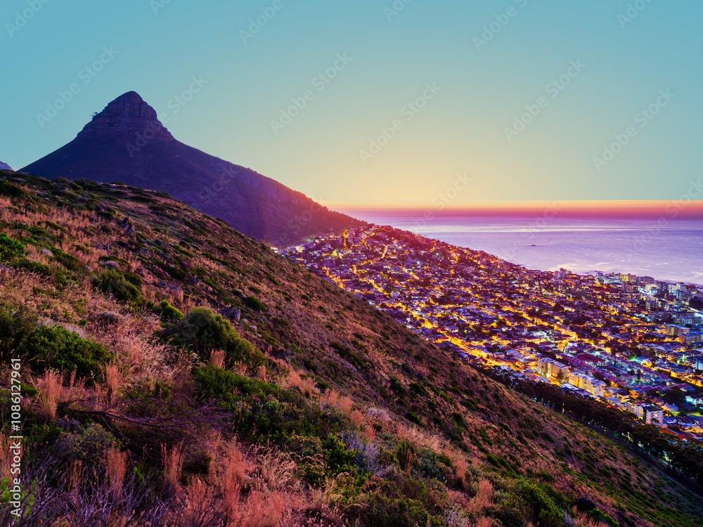 After sunset view of Camps Bay and Bakoven lit up on the slopes of Lion's Head mountain, Cape Town, South Africa