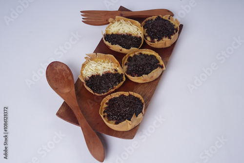 Martabak mini or terang bulan mini is Indonesian popular street food, made from flour, egg, yeast, topped with cheese or chocolate. Mini sweet martabak isolated on white background. photo