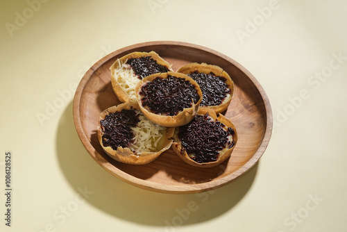 Martabak mini or terang bulan mini is Indonesian popular street food, made from flour, egg, yeast, topped with cheese or chocolate. Mini sweet martabak isolated on yellow background. photo