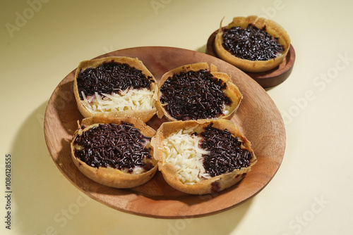 Martabak mini or terang bulan mini is Indonesian popular street food, made from flour, egg, yeast, topped with cheese or chocolate. Mini sweet martabak isolated on yellow background. photo