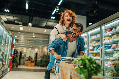 Fotografija Happy couple having fun while shopping in supermarket