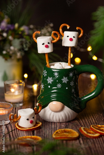 Cute two marshmallow reindeers in green cup on dark background christmas fun dessert