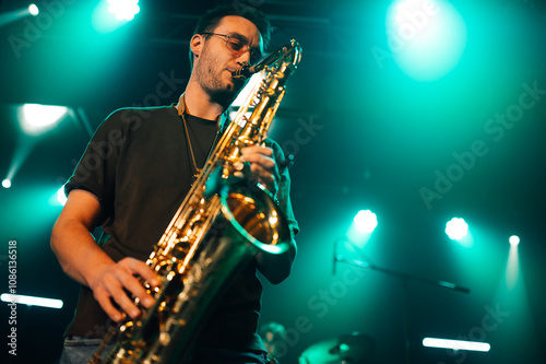 Photography Saxophonist performing live on stage with teal lighting