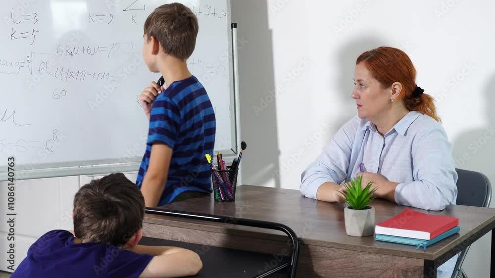 Teacher has lesson with pupils, white board and communications during process Teacher has lesson with pupils, white board and communications during process
