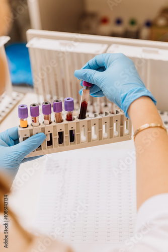 Laboratory technician handling blood samples in test tubes for analysis and diagnostics