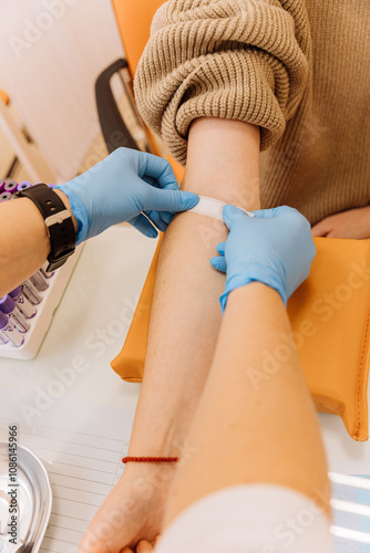 Healthcare professional applying a bandage after a blood draw procedure in a clinical setting