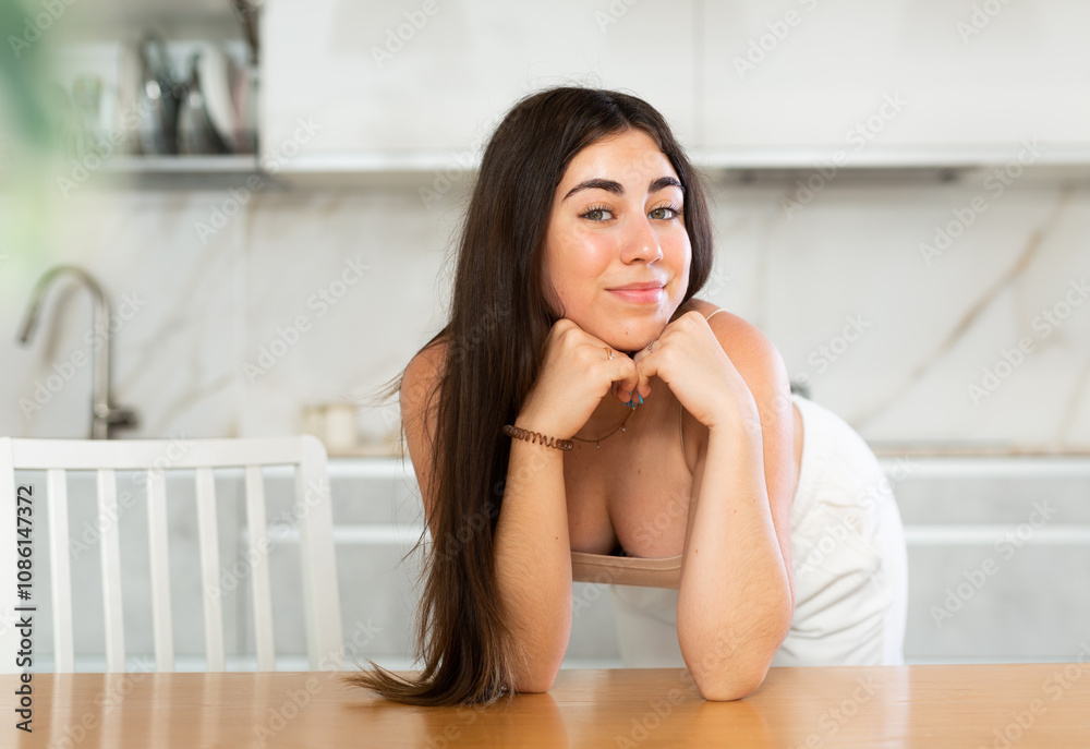 Young smiling woman in casual clothes posing in kitchen at home Young smiling woman in casual clothes posing in kitchen at home