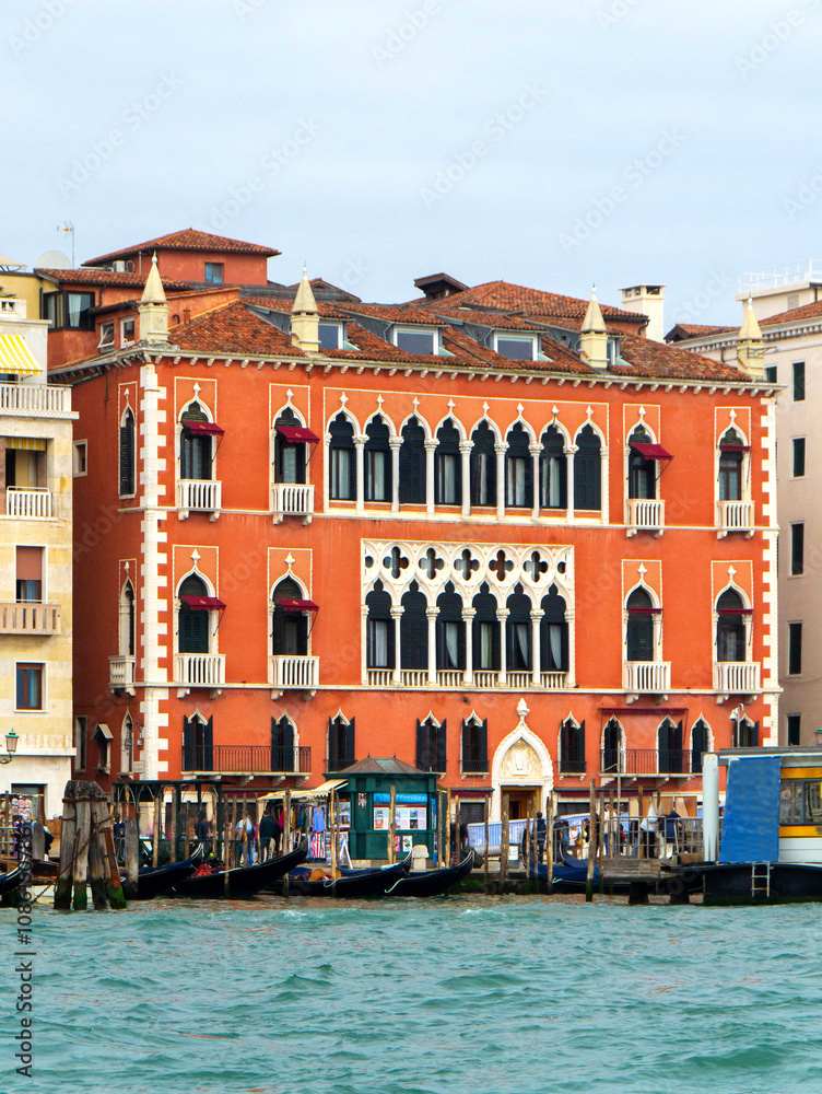 Fototapeta premium A view of historic Venetian buildings along the Grand Canal, showcasing classic Italian architecture. The iconic canal waters reflect the facades, with boats and gondolas adding to the charm of Venice
