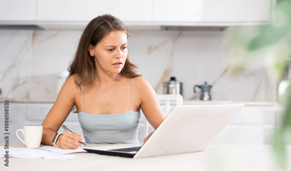 Woman, working from home, is visibly drained from her remote tasks.