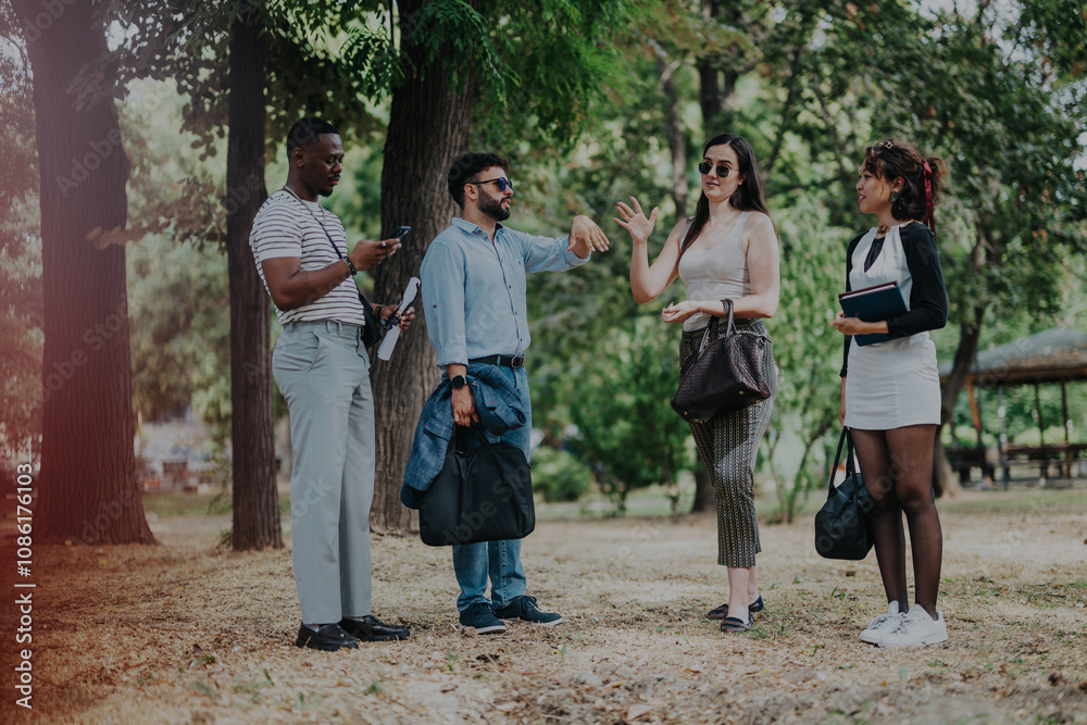 Group of business people engaging in a casual outdoor meeting in a park setting. They are dressed in smart casual attire, discussing work-related matters amidst a natural, relaxed environment. Group of business people engaging in a casual outdoor meeting in a park setting. They are dressed in smart casual attire, discussing work-related matters amidst a natural, relaxed environment.