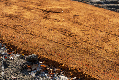 Construction photos of new baseball, softball, sports field red clay pitchers mound and infield clay surfacing.
 photo