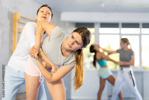 Girl and woman athletes practice self-defense wrestling. Training at Academy of Martial Arts martial arts hand-to-hand combat.