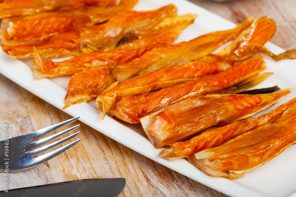 Plate with smoked salmon bellies on wooden background. Fish appetizer.. Plate with smoked salmon bellies on wooden background. Fish appetizer..