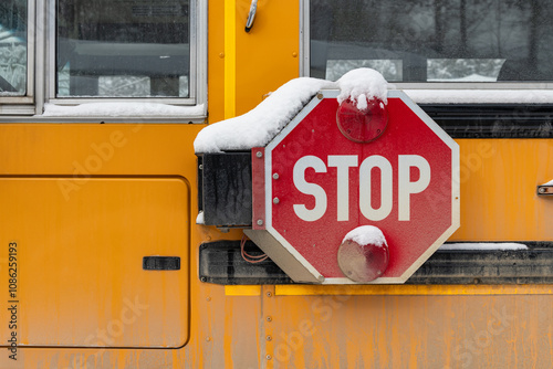Snow covered stop arm on a school bus in winter