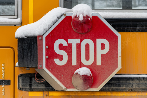 Winter scene of a snow covered stop arm on a school bus