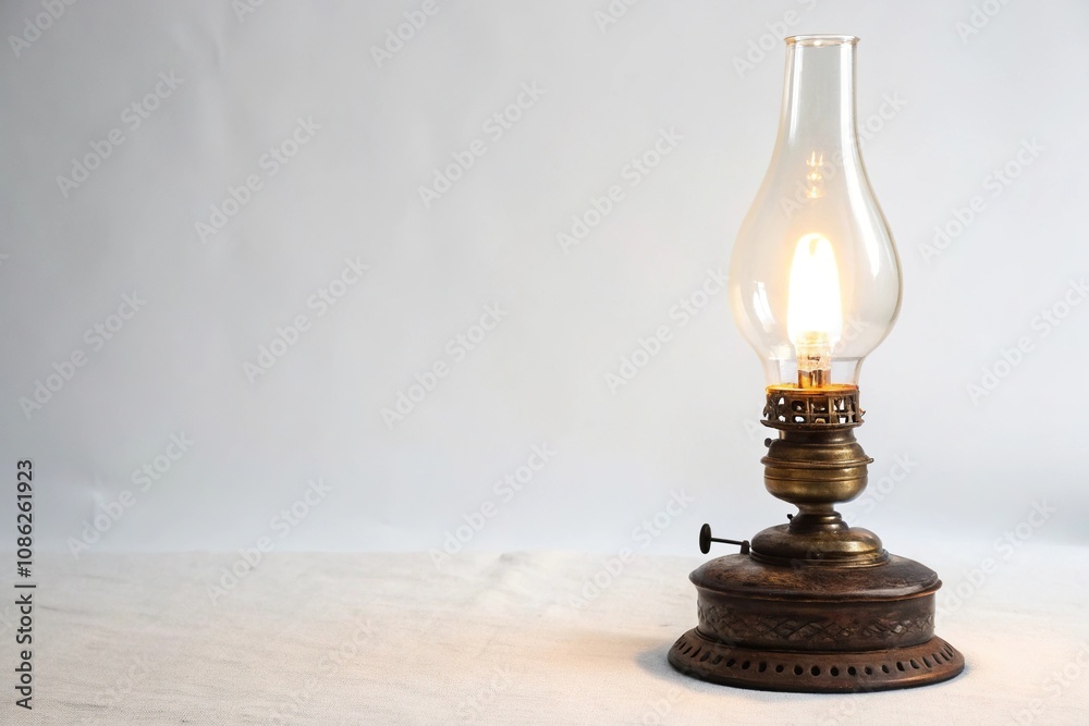Antique kerosene lamp sitting alone on a minimalist white background with soft warm glow emanating from its base and upper light source, lighting, white background, minimalist, home decor Antique kerosene lamp sitting alone on a minimalist white background with soft warm glow emanating from its base and upper light source, lighting, white background, minimalist, home decor