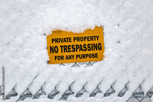 No trespassing sign covered in snow