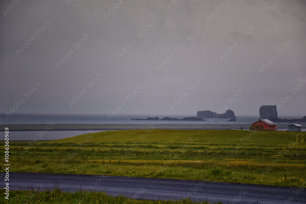 Fototapeta premium Reynisfjara black-sand beach found on the Ocean South Coast of Iceland, basalt columns and the dramatic Reynisdrangar sea stacks. Iceland, Europe.