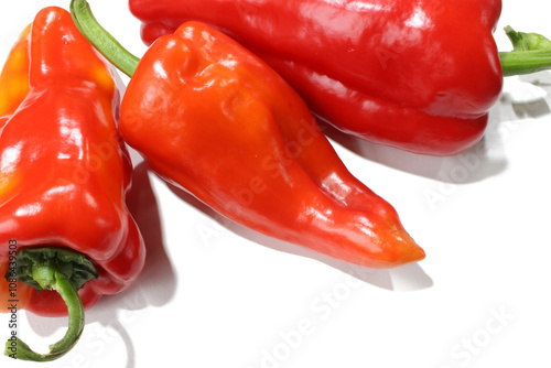 Three red peppers on a white background