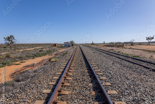 A railway track running through Olary, a shrinking village with its abandoned station and few buildings because of the declining importance of rail transport and mining ore in Eastern South Australia. photo