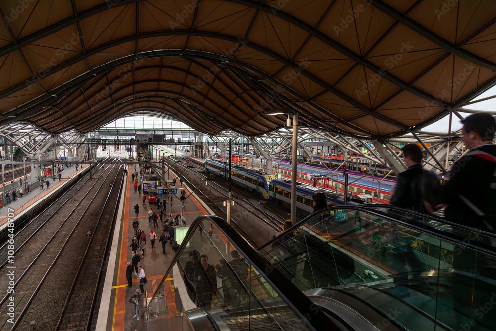 Fototapeta premium Southern Cross Station in Melbourne with modern architecture, trains, and bustling commuters
