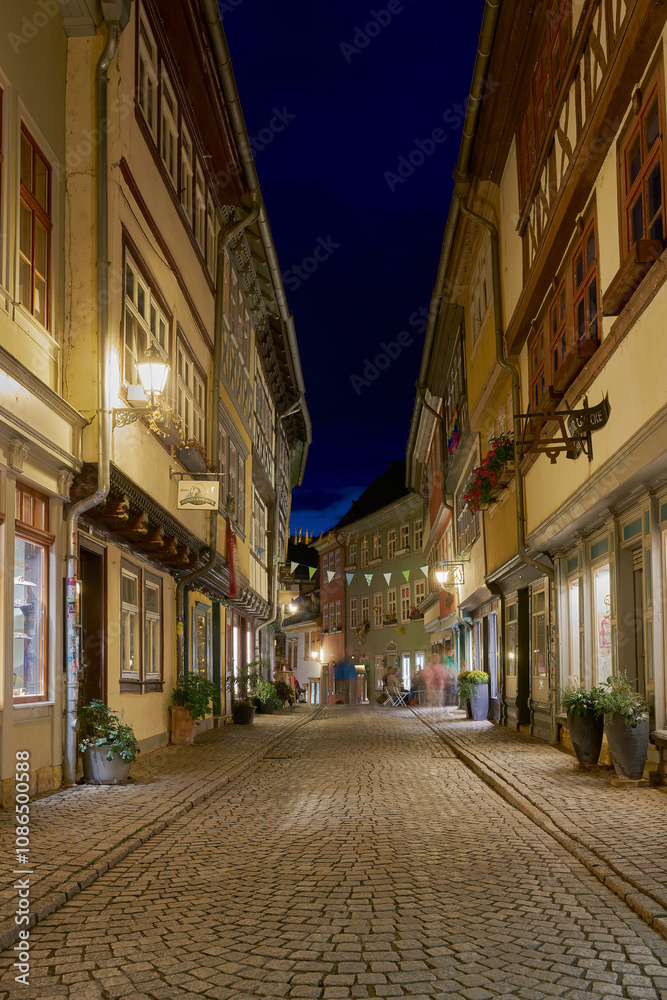 Obraz premium Die Krämerbrücke in Erfurt in Deutschland mit einigen Geschäften in historischen Häusern auf beiden Seiten der Brücke bei Nacht