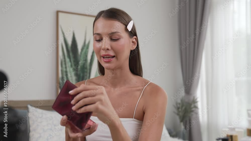Young woman start live streaming beauty and cosmetic tutorial video content for social media. Beauty blogger smiles to camera while showing how to beauty care to audience or followers. Adit Young woman start live streaming beauty and cosmetic tutorial video content for social media. Beauty blogger smiles to camera while showing how to beauty care to audience or followers. Adit
