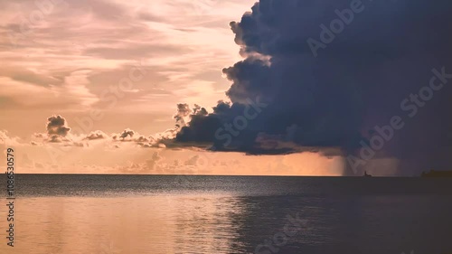 A rapidly approaching cloud over the sea horizon rained down on a lonely lighthouse not far from the shore.
