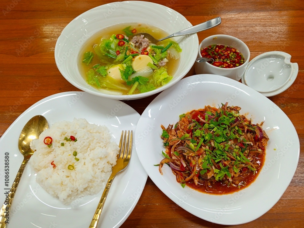 A simple yet satisfying Thai meal consisting of steamed rice, clear tofu soup, and spicy canned fish salad.