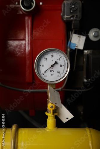 Modern interior of the boiler room with gas boilers and pipes for supplying gas and steam, water pump, valves, manometers close up. photo