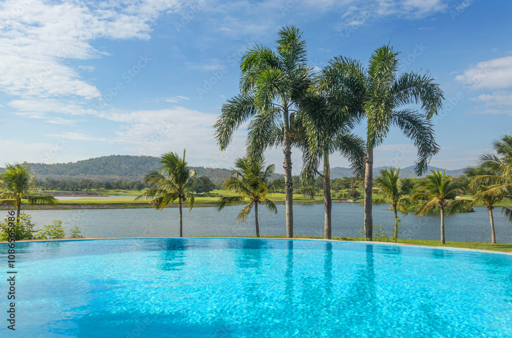 Private luxury blue infinity pool surrounded with palm trees Private luxury blue infinity pool surrounded with palm trees