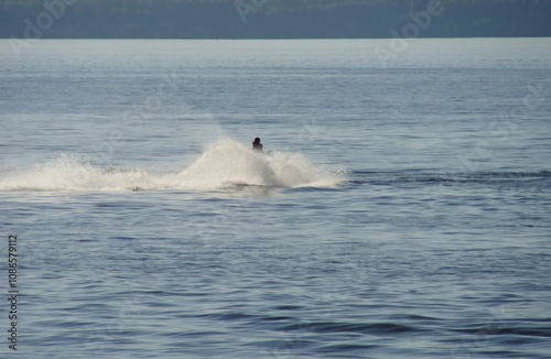 Turns on a jet ski surrounded by water splashes on the river
