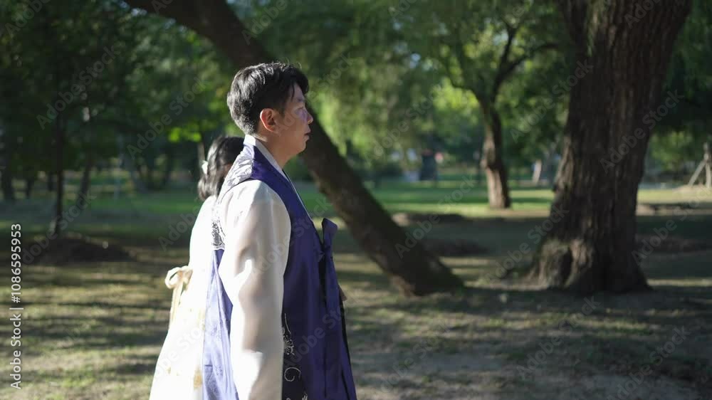 A Korean couple, a man in his 30s and a woman in her 20s, spends time together at a historical park in Seoul, South Korea. Slow motion video. A Korean couple, a man in his 30s and a woman in her 20s, spends time together at a historical park in Seoul, South Korea. Slow motion video.