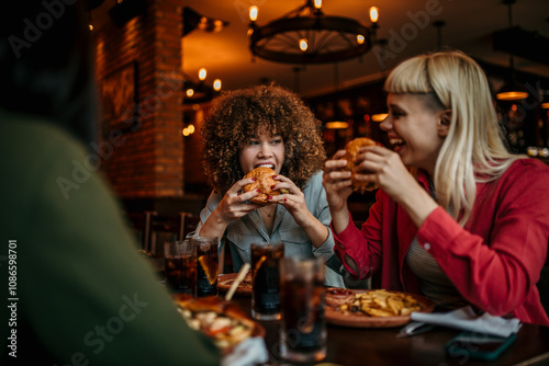 Photo of a young woman eating out in a restaurant with friends. Food and people concept