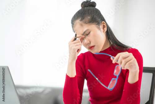 A businesswoman sits at her desk, stressed and anxious while looking at her laptop. She talks online, analyzes tasks, and struggles to plan effectively, battling pessimism and work pressure. photo