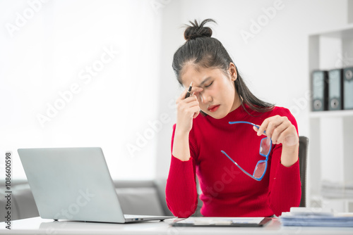 A businesswoman sits at her desk, stressed and anxious while looking at her laptop. She talks online, analyzes tasks, and struggles to plan effectively, battling pessimism and work pressure. photo