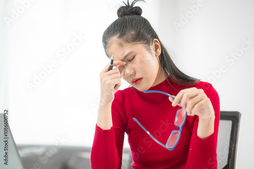 A businesswoman sits at her desk, stressed and anxious while looking at her laptop. She talks online, analyzes tasks, and struggles to plan effectively, battling pessimism and work pressure. photo