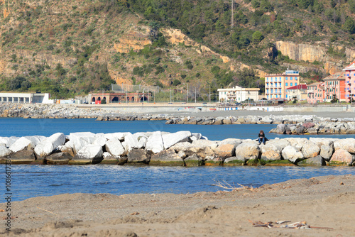 Breakwater on Mediterranean beach. Nature of sea and mountains. Setri Levante, Liguria.  photo