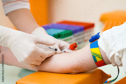 Collecting a blood sample at a medical facility. A healthcare professional is drawing blood from a patient's arm for medical testing in a clean environment. photo