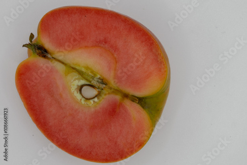 Cut in half kissabel apple against white background. Hidden rose apples, pink inside apple photo