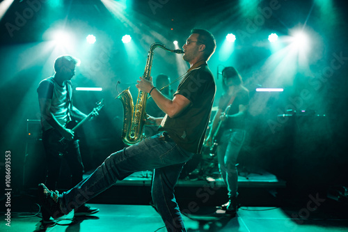 Photography Saxophonist performing with band on stage during music concert