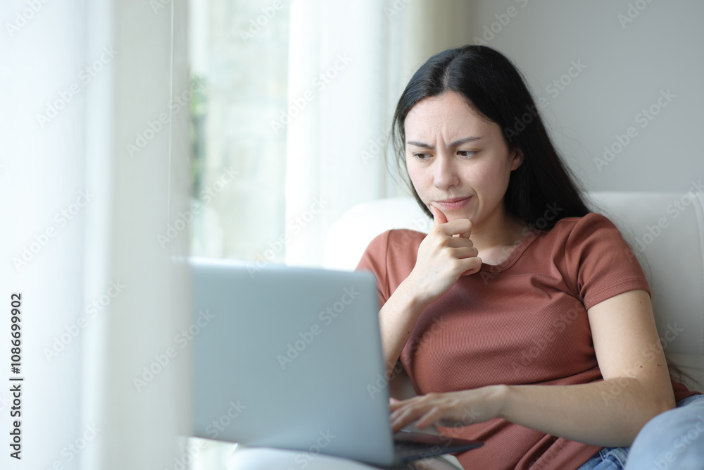 Suspicious asian woman checking laptop content at home Suspicious asian woman checking laptop content at home
